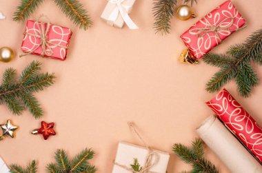 Noel ve Yeni Yıl tatili geçmişi. Xmas tebrik kartı. Noel hediyeleri kutuları kağıt ve çam dalları ile sarılı bej arka plan görünümlü. 