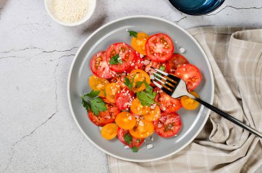 Healthy salad with red and yellow cherry tomato, sesame and parsley in plate. Summer food concept. Selective focus