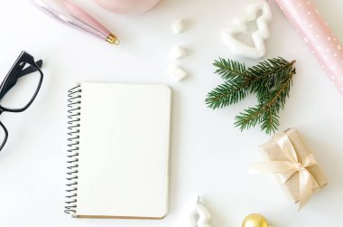 Boş defter, gözlük ve Noel süslemesi. Hedef belirleme, bilgilendirme kavramı. Sıcak bir tatil ve yeni yıl konsepti.