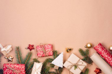 Noel ve Yeni Yıl tatili geçmişi. Xmas tebrik kartı. Noel hediyeleri kutuları kağıt ve çam dalları ile sarılı bej arka plan görünümlü. 