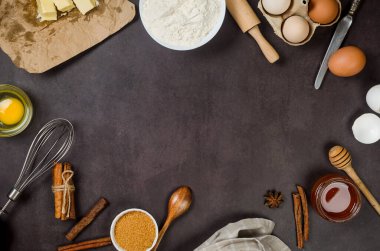 Koyu mutfak atölyesinde un, yumurta, şeker ve tarçın içeren ev yapımı kurabiyeler pişirmek. Mutfak arka planı, kopyalama alanı, genel yaşam