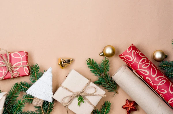 Noel ve Yeni Yıl tatili geçmişi. Xmas tebrik kartı. Noel hediyeleri kutuları kağıt ve çam dalları ile sarılı bej arka plan görünümlü. 