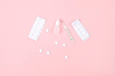 Medicines for treatment- pills, spray bottles, blister and thermometer on pink background, Pharmaceuticals and medicine. Illness concept. 
