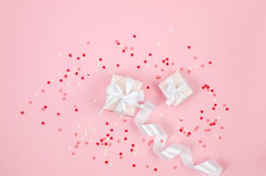 Şeker kalpler konfetisi ve pembe arka planda hediye kutusu. Sevgililer Günü konsepti. Düğünler, nişanlar, Anneler Günü, doğum günü. Metin için yeri olan tebrik kartı 