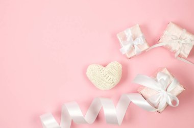 Gift box and red paper hearts on pink background. Concept of Valentine day. Greeting card for Valentine,  Mother day or birthday.