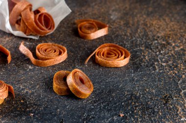 Koyu arka planda kaygan meyve ruloları. El yapımı meyveli börek. Detoks konsepti. Şekersiz, sağlıklı beslenme, tatlılık.