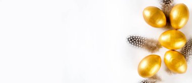 Süslü altın yumurtalar ve beyaz arka planda tüyler. Mutlu Paskalyalar asgari konsepti. Paskalya bayramında düzdü. Mutlu Paskalyalar. Metin için alanı kopyala.