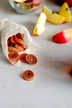 Açık gri masada kaygan meyve dürümleri. El yapımı meyveli börek. Detoks konsepti. Şekersiz, sağlıklı beslenme, tatlılık.