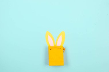 Paskalya Bayramı çikolatalı yumurtalar ve pastel mavi arka planda kağıt tavşan kulakları. Paskalya tatili ve gelenek kavramı. Tatil için hazırlık. 