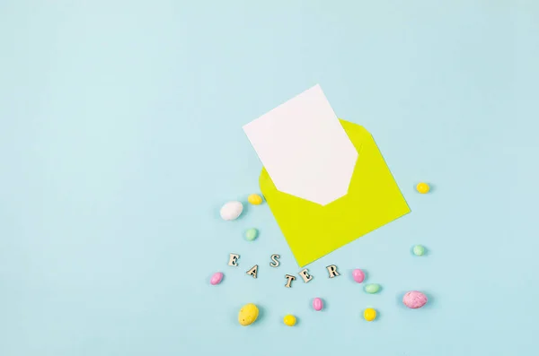 Kleurrijke Snoep Paaseieren Blauwe Achtergrond Gele Envelop Met Blanco Kaart — Stockfoto