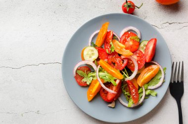 Healthy salad with red and yellow cherry tomato, sesame and parsley in plate. Summer food concept. Selective focus
