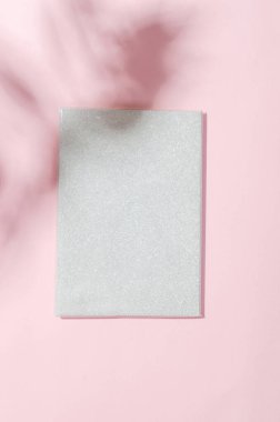 Pembe arka planda yaprakların gölgesi olan boş beyaz defter. Marka kimliği için zarif modern şablon. Yaz konsepti için asgari doğa geçmişi. Düz yatış, üst görünüm.