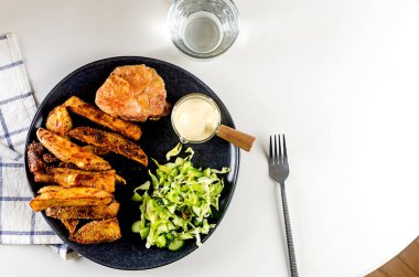 Baharatlı fırında patates ve lezzetli öğle yemeği için tabakta salata. Fırın kabında sebzeyle pişirilmiş chike. Lezzetli yemek.. 