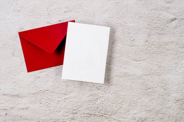 Üzerinde gri beton arkaplan yazılı mesaj için beyaz kart olan kırmızı zarf. Boş davet veya kopyalama alanı olan tebrik kartı modeliName