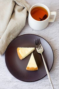 Klasik vanilyalı Cheesecake New York tabağı, Yakından Bakış. Gri arkaplanda nane yaprağı olan lezzetli peynirli kek.. 