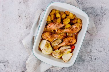 Kızarmış tavuk bacağı, patates, soğan ve havuç tablada salata ve masada lezzetli bir öğle yemeği..