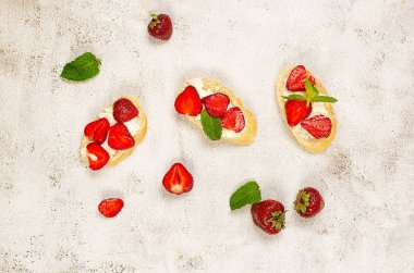 Açık sandviçler, krem peynirli zanaatkar ekmek, taze çilek ve çimento kaplı taze naneli bitki. Atıştırmalık, sağlıklı kahvaltı., 