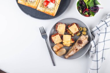 Kızarmış balık ve masada öğle yemeği için peynirli fırında patates.. 