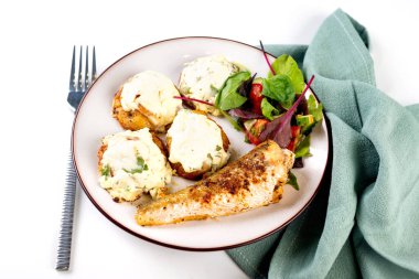 Kızarmış balık ve masada öğle yemeği için peynirli fırında patates.. 