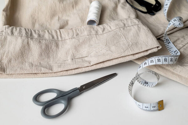 linen trousers with tools to repair old clothes. Sewing and home needlework. Circular fashion, fast fashion, Sustainable, zero waste lifestyle concept
