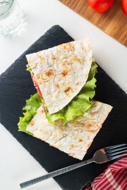 Et, sos, peynir, domates ve salata yapraklı quesadilla. Klasik geleneksel Meksika yemekleri işte. Pita ekmeğinde ızgara burger.. 