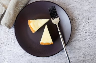 Klasik vanilyalı Cheesecake New York tabağı, Yakından Bakış. Gri arkaplanda nane yaprağı olan lezzetli peynirli kek.. 