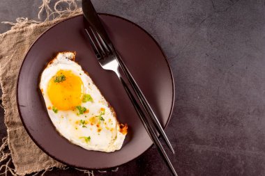 Kahvaltı için peynirli sandviç ve domates salatasıyla birlikte getirilmiş yumurta..