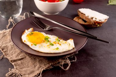 Kahvaltı için peynirli sandviç ve domates salatasıyla birlikte getirilmiş yumurta..