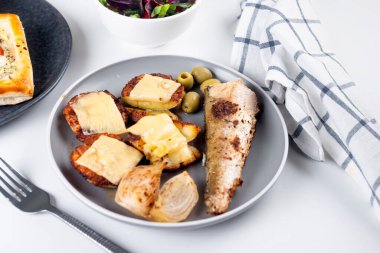 Kızarmış balık ve masada öğle yemeği için peynirli fırında patates.. 