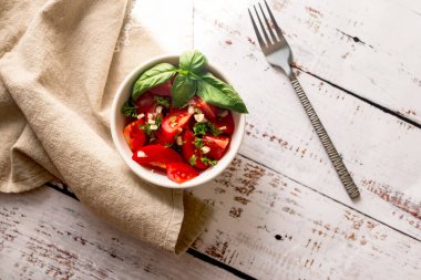 Sağlıklı kahvaltı ya da öğle yemeği için hafif arka planda domates ve fesleğen salatası.. 