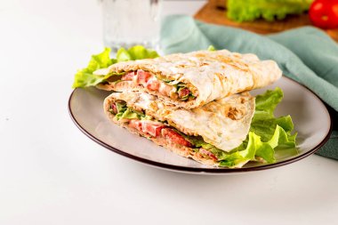 Et, sos, peynir, domates ve salata yapraklı quesadilla. Klasik geleneksel Meksika yemekleri işte. Pita ekmeğinde ızgara burger.. 