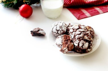 Noel için ev yapımı çikolatalı mermer kurabiyeler ve masada sütlü çay. Geleneksel Amerikan çikolatalı kurabiyeleri Noel için çatallı ve pudra şekerli.