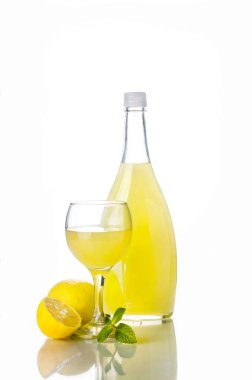 Geleneksel İtalyan likörü Limoncello likörü, şarap bardağı ve beyaz üzerine taze limon.