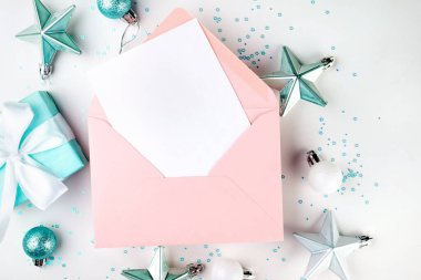 Pembe zarf içinde boş bir kart, mavi ve beyaz toplar, beyaz mücevherler. Yılbaşı partisi. Tebrik kartı, kopyalama alanı olan şablon. 