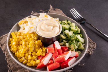 Mısır, yumurta, salatalık ve kasede sosis mayonezli doğranmış yengeç salatası. Deniz ürünleri lezzetleri..