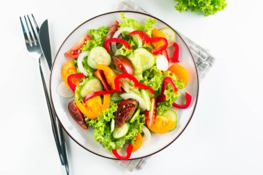 Taze domatesli sebze salatası, salatalık, soğan, beyaz tabakta marul. Lezzetli ve sağlıklı yemek kavramı.. 