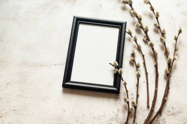 Bahar Paskalya kompozisyonu. Boş siyah çerçeve ve bahar söğüt dalları. Tarafsız renkler. Paskalya arkaplanı.