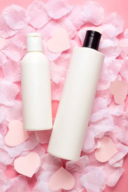 Beyaz makyaj malzemeleri, pembe arka planda şampuan şişeleri. Saç bakımı kavramı. 