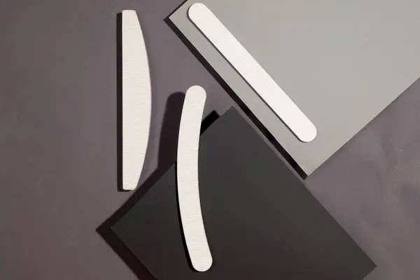 さまざまな形状の灰色の釘ファイルとダークグレーの背景の異なる剛性のセット アイソメトリック マニキュアのためのツール ストック写真