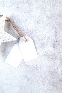 El sanatları hediye kutularındaki beyaz boş kağıt etiket ve gri arka plandaki Noel dekoru. Noel tebrik kartı maketi.