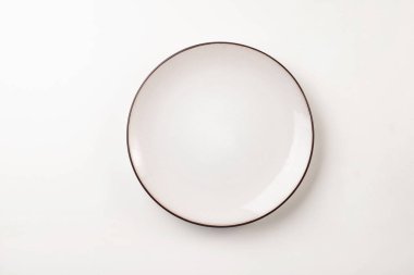 Kahverengi kenarlı, beyaz bir tabak. Yemek fotoğrafçılığı ve sofra takımı için mükemmel., 