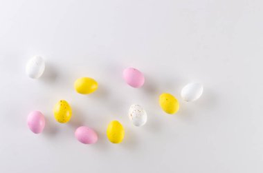 Mutlu Paskalyalar! Beyaz üzerine renkli Paskalya çikolatası. Paskalya tebrik kartı, metin için alanı olan bahar şablonu. 