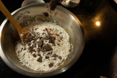 Çikolata parçacıklı kurabiye karışımına çikolata parçaları ekliyorum.