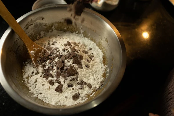 Çikolata parçacıklı kurabiye karışımına çikolata parçaları ekliyorum.