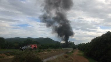 Dark smoke group beside the road with irrigation canal in countryside, air pollution, global warming. Full hd footage.