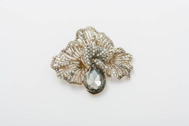 Altın yapraklı metal broş ve taş taklidi, beyaz arka planda izole edilmiş iğne, bijouterie, yakın takı.