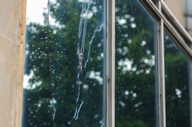 Kırık cam ve yağmur damlaları. Ofis binası savaş uçağı tarafından hasar gördü. Terörist eylemi. Sivil altyapı yıkıldı