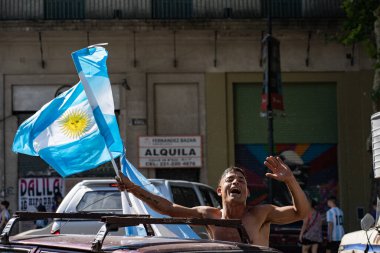 La Plata, Buenos Aires, Arjantin - 18 Aralık 2022: Arjantin bayrağı taşıyan bir taraftar Arjantin 'in Katar' daki 2022 FIFA Dünya Kupası 'nı kazanmasını kutluyor.