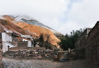 Iruya, Salta, Arjantin 'de kerpiç evleri ve renkli karlı dağlarla koloni darlığı