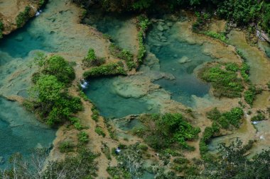 Guatemala 'nın Lanquin kasabası yakınlarındaki Alta Verapaz ormanlarında bulunan doğal bir anıt olan Semuc Champey' in hava manzarasını kapatın. Bu doğal cennetin doğal kireçtaşı köprüsünün üzerinde turkuaz renkli havuzları var. 